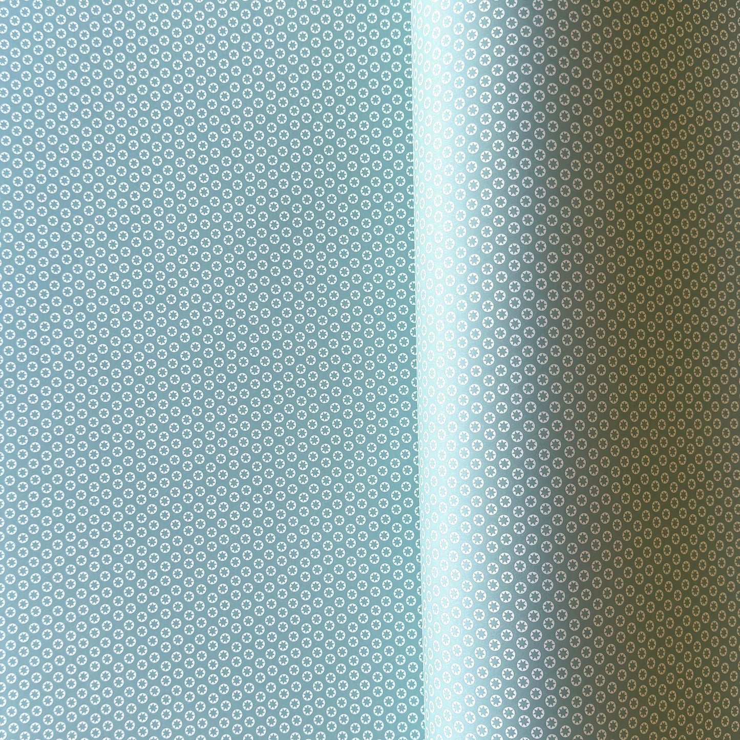 wrapping paper with an abstract tiny stars pattern in ice blue and white by Ola Studio