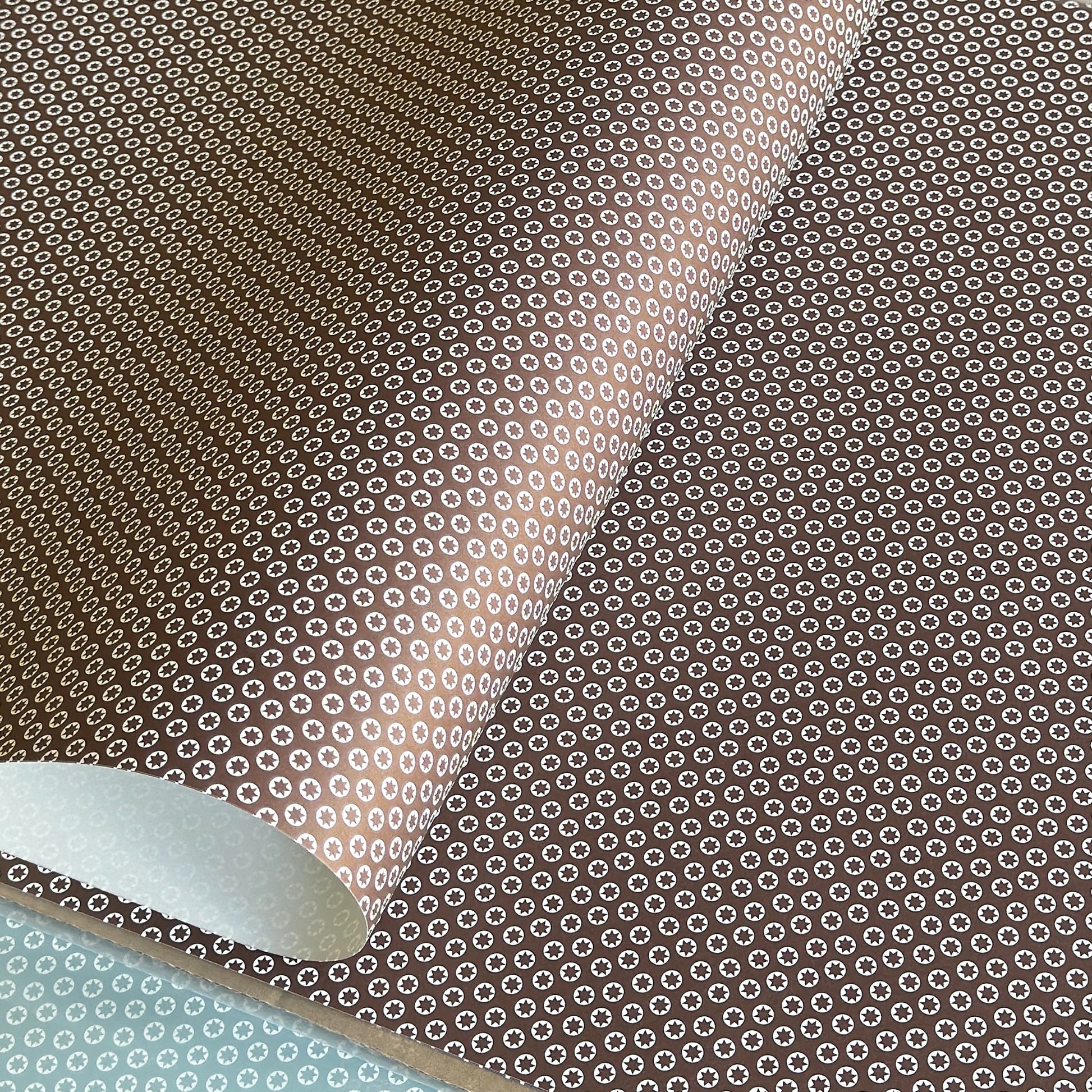 wrapping paper with an abstract tiny stars pattern in chestnut brown and white by Ola Studio