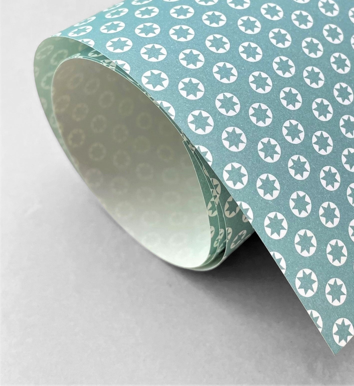 wrapping paper with an abstract tiny stars pattern in ice blue and white by Ola Studio