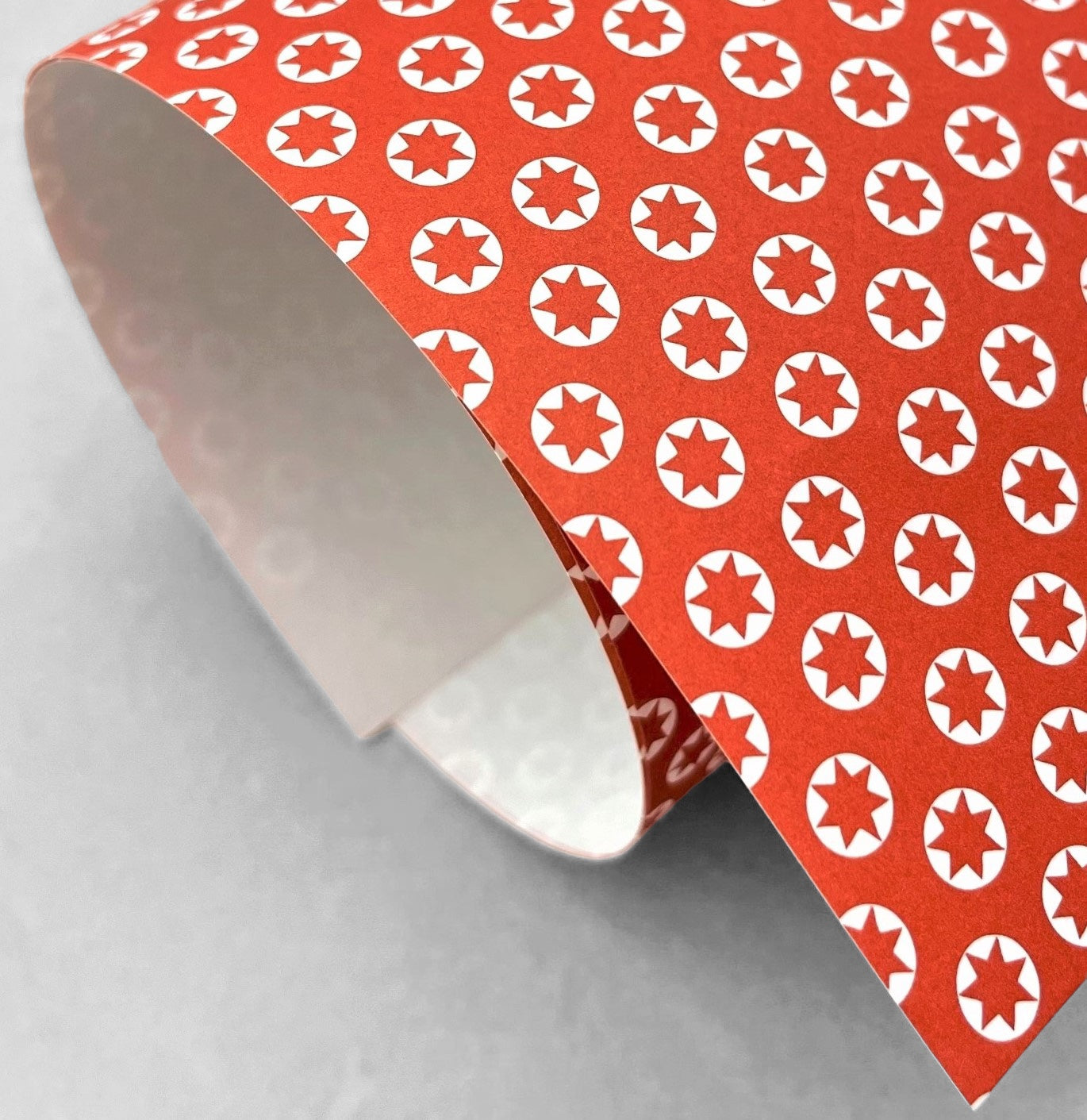 wrapping paper with an abstract tiny stars pattern in red and white by Ola Studio