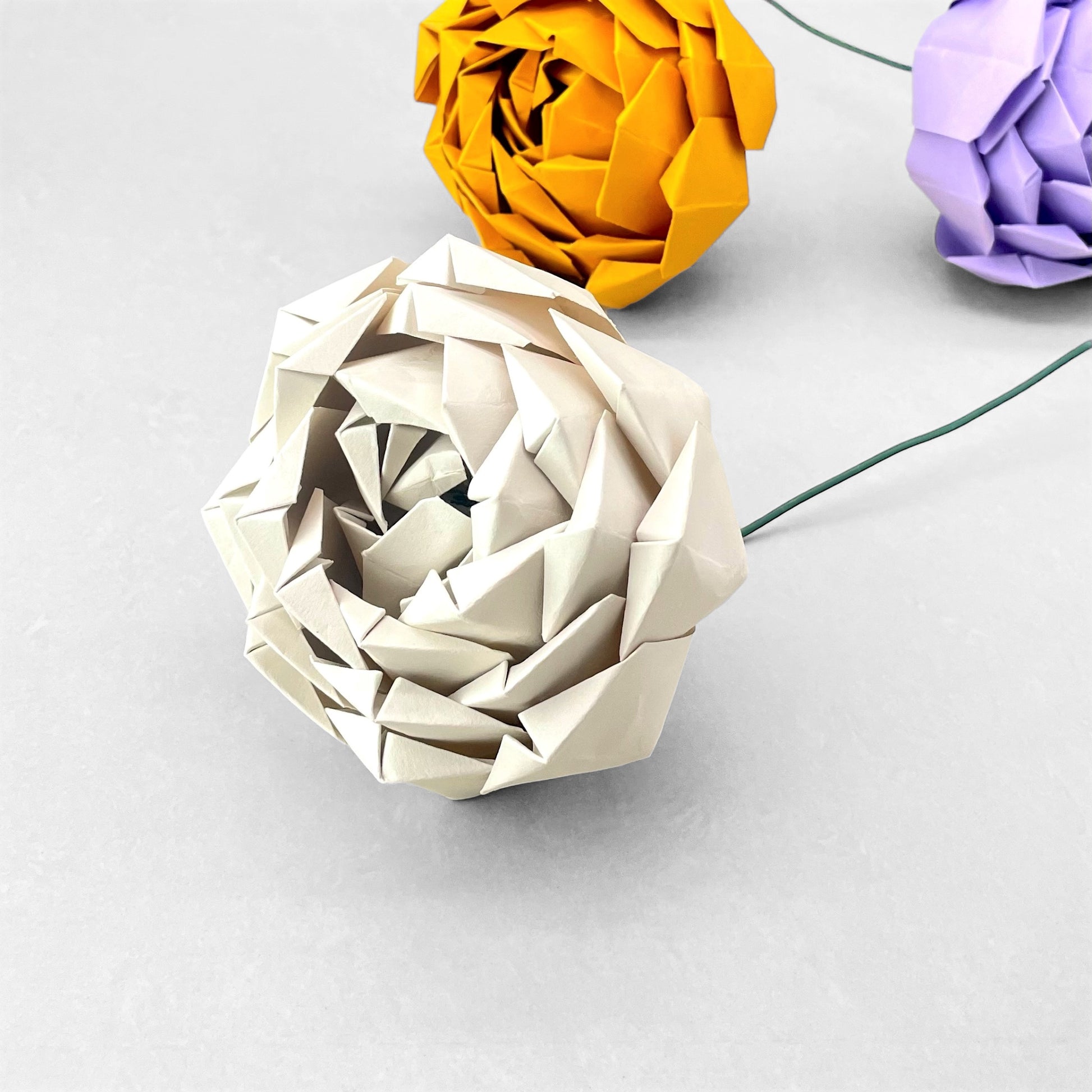 A paper craft kit by Origami Est to create 3 paper peonies.  Peonies are pictured in cream, mustard and lilac