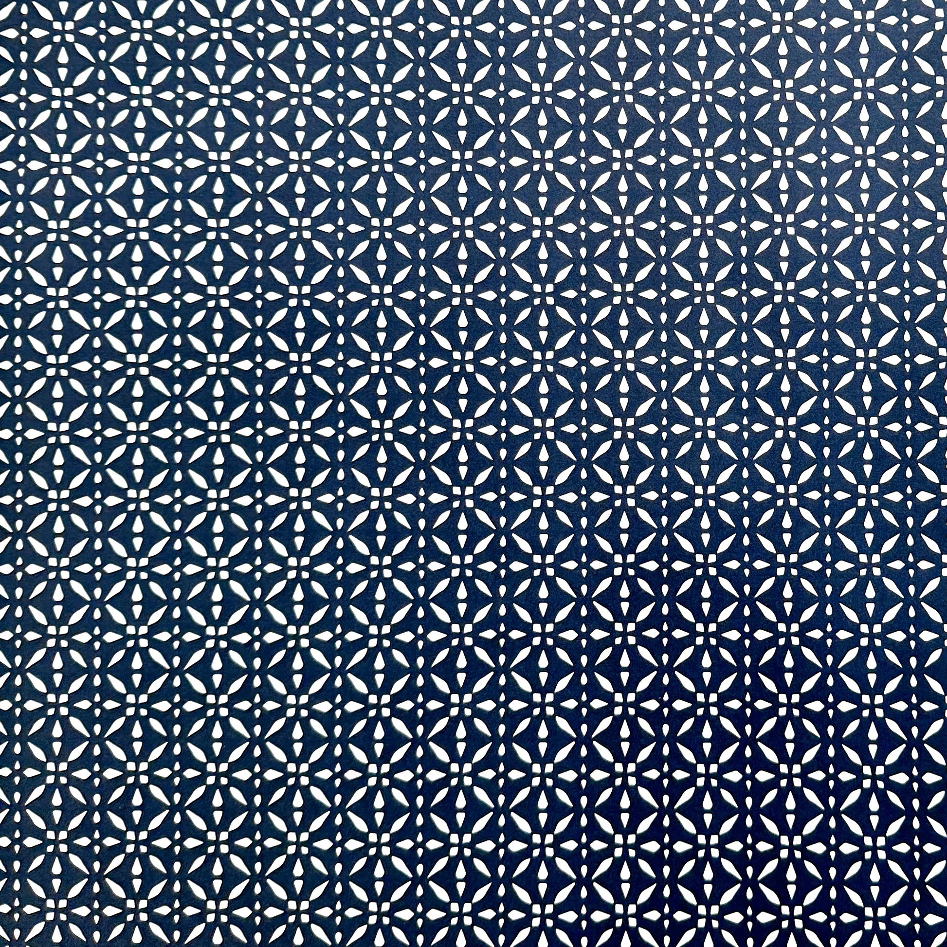 wrapping paper by Otto Editions with a cut-out design in white on an indigo blue background. 