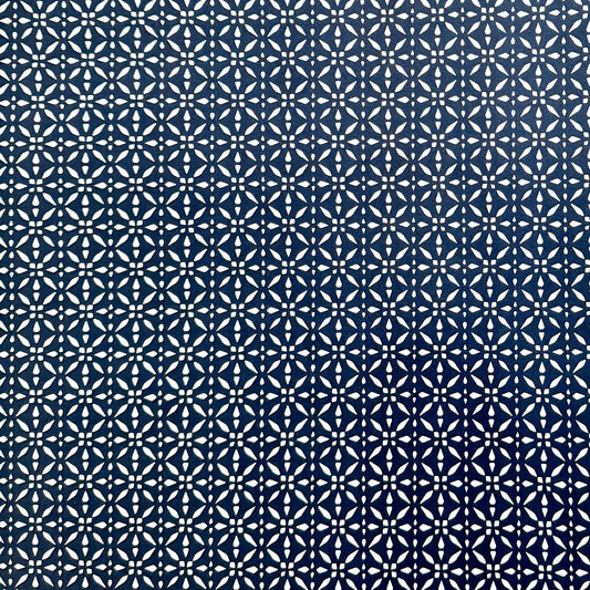 wrapping paper by Otto Editions with a cut-out design in white on an indigo blue background. 