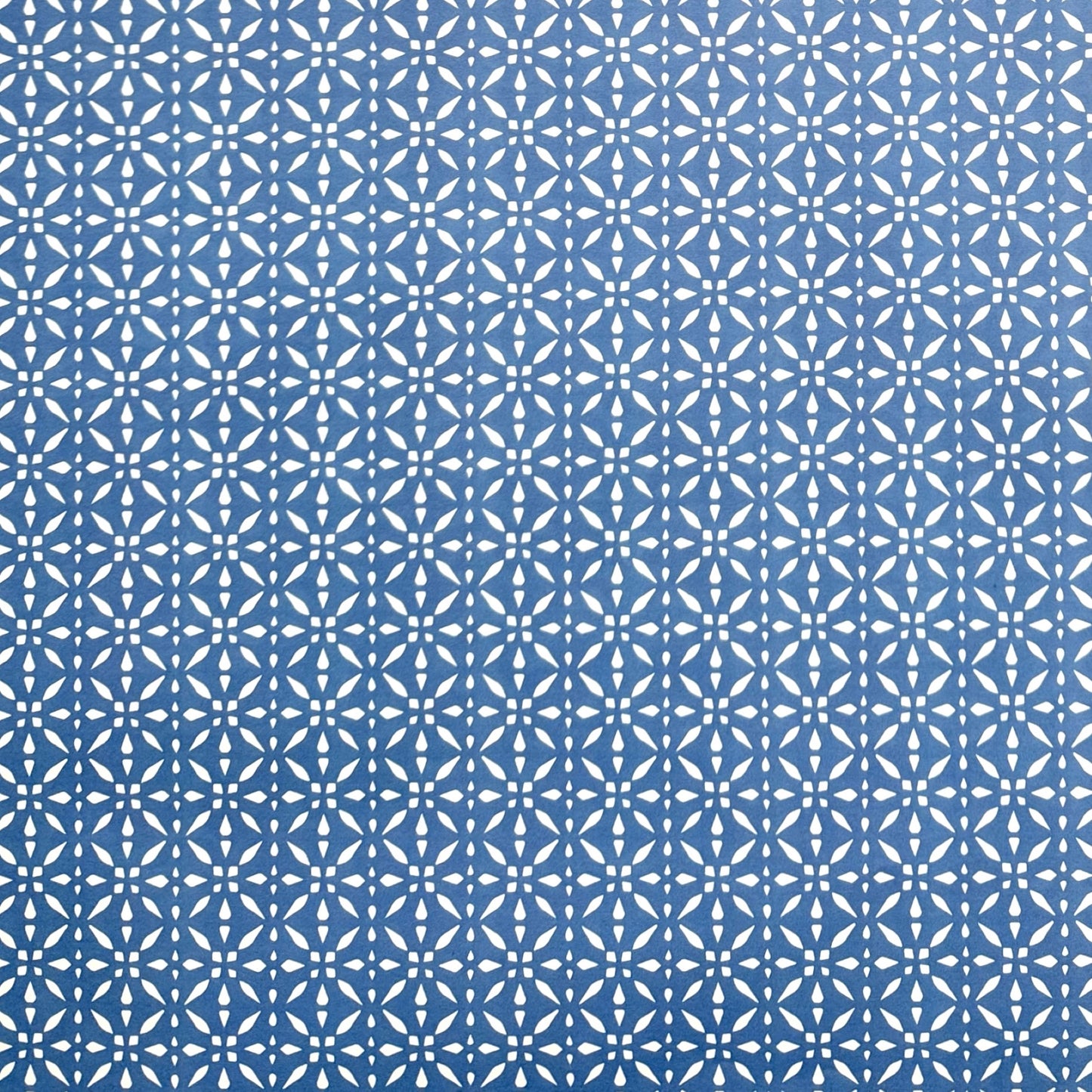 wrapping paper by Otto Editions with a cut-out design in white on a sky blue background. 