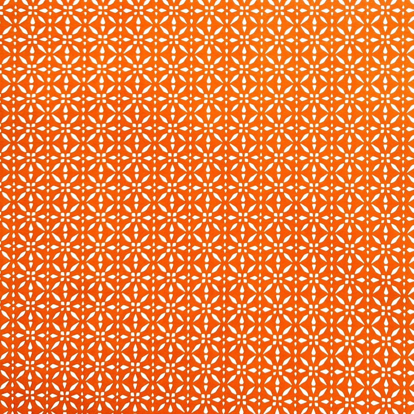 wrapping paper by Otto Editions with a cut-out design in white on a spice orange background. 