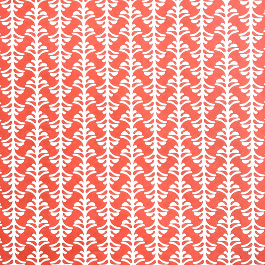 wrapping paper by Otto Editions with a cut-out palm design in white on a coral pink background. 