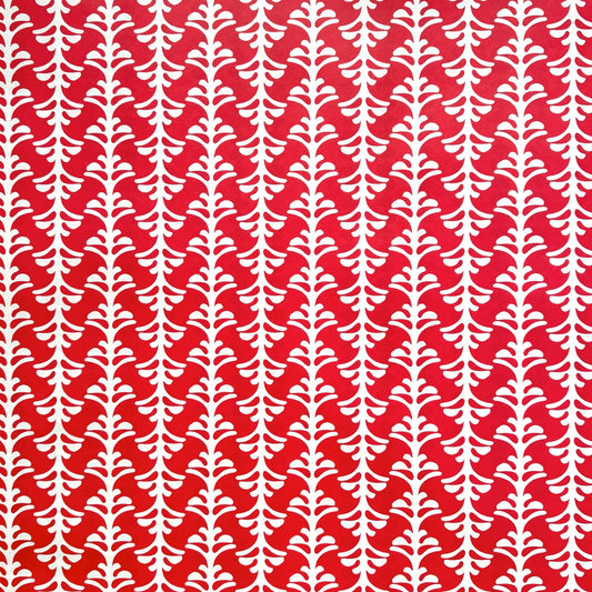 wrapping paper by Otto Editions with a cut-out palm design in white on a hibiscus pink background. 