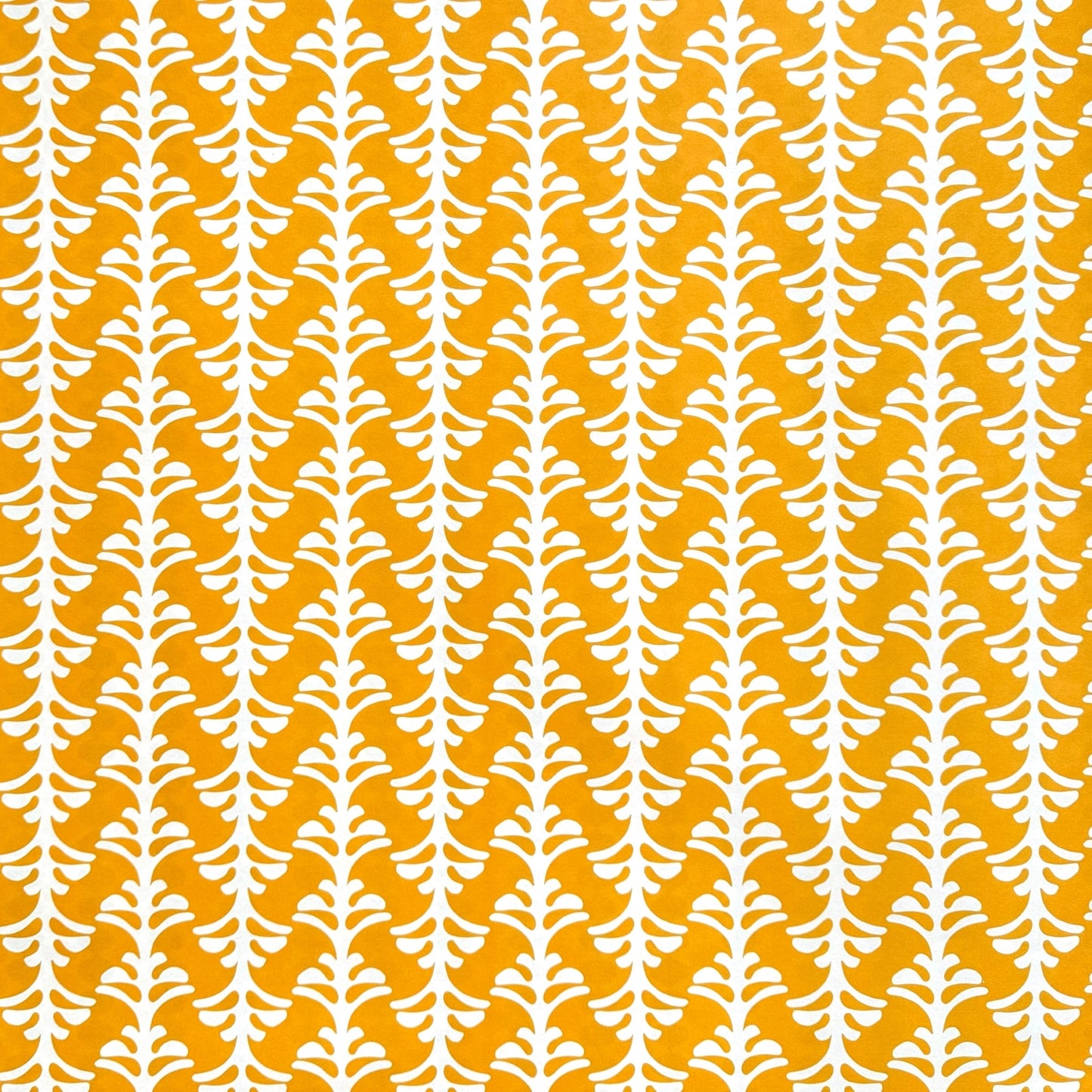 wrapping paper by Otto Editions with a cut-out palm design in white on a saffron yellow background. 