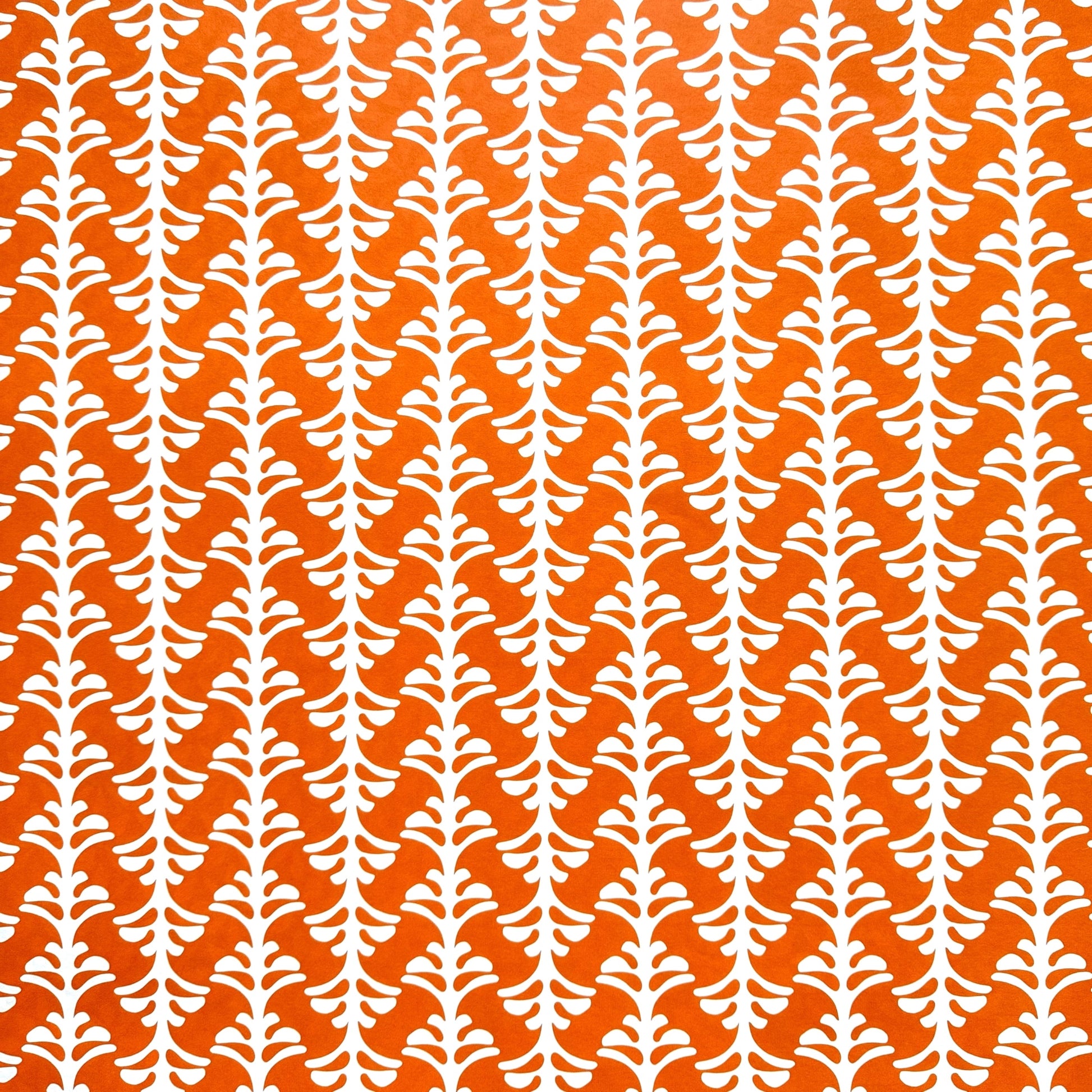 wrapping paper by Otto Editions with a cut-out palm design in white on a spice orange background. 
