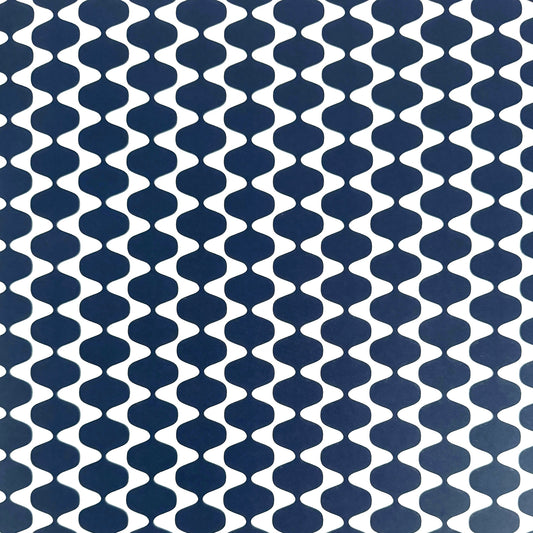wrapping paper by Otto Editions with a cut-out wavy design in white on an indigo background. 