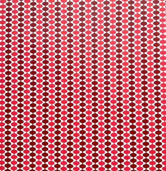 wrapping paper by Otto Editions with a cut-out wavy design in white on a pink and burgundy background. 