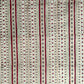 Hand block printed wrapping paper with a striped design in red, green and gold. 