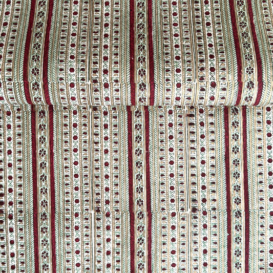 Hand block printed wrapping paper with a striped design in red, green and gold. 