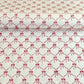 a sheet of hand block printed paper with a red and pink bow design on white