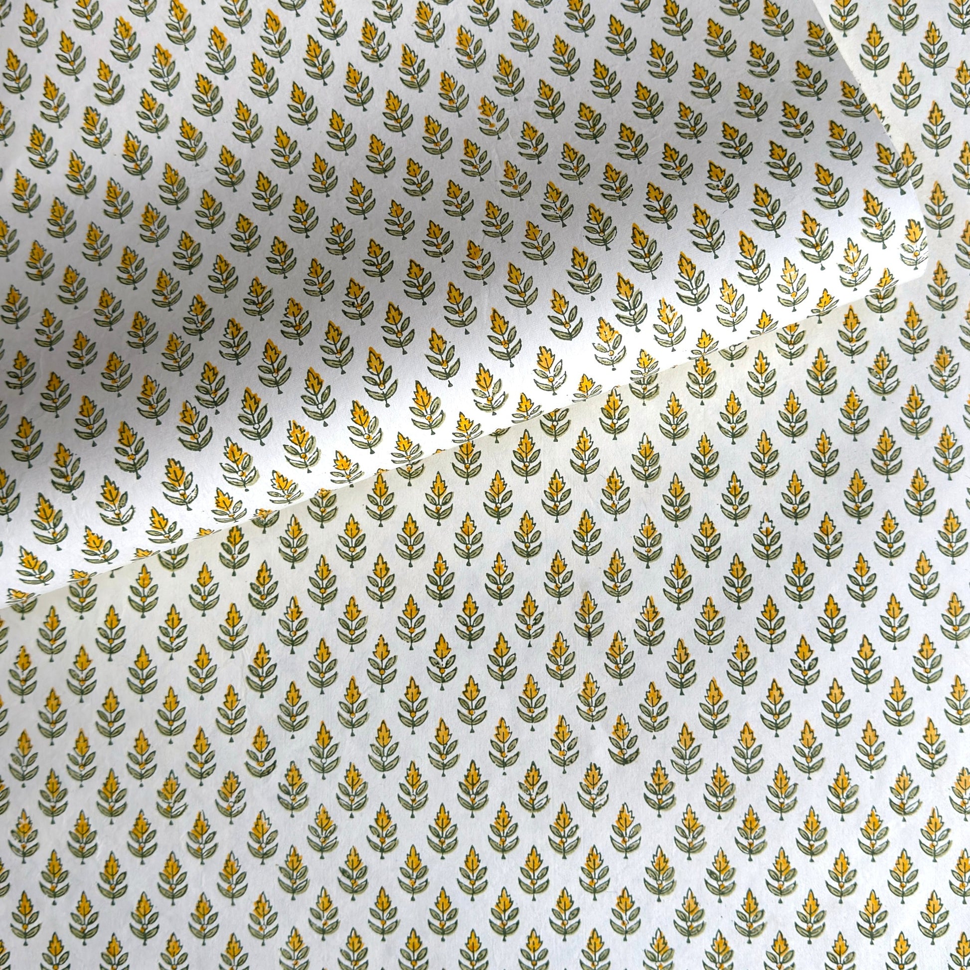 Wrapping paper with block print small flower motif in yellow and green, white background by Paper Mirchi