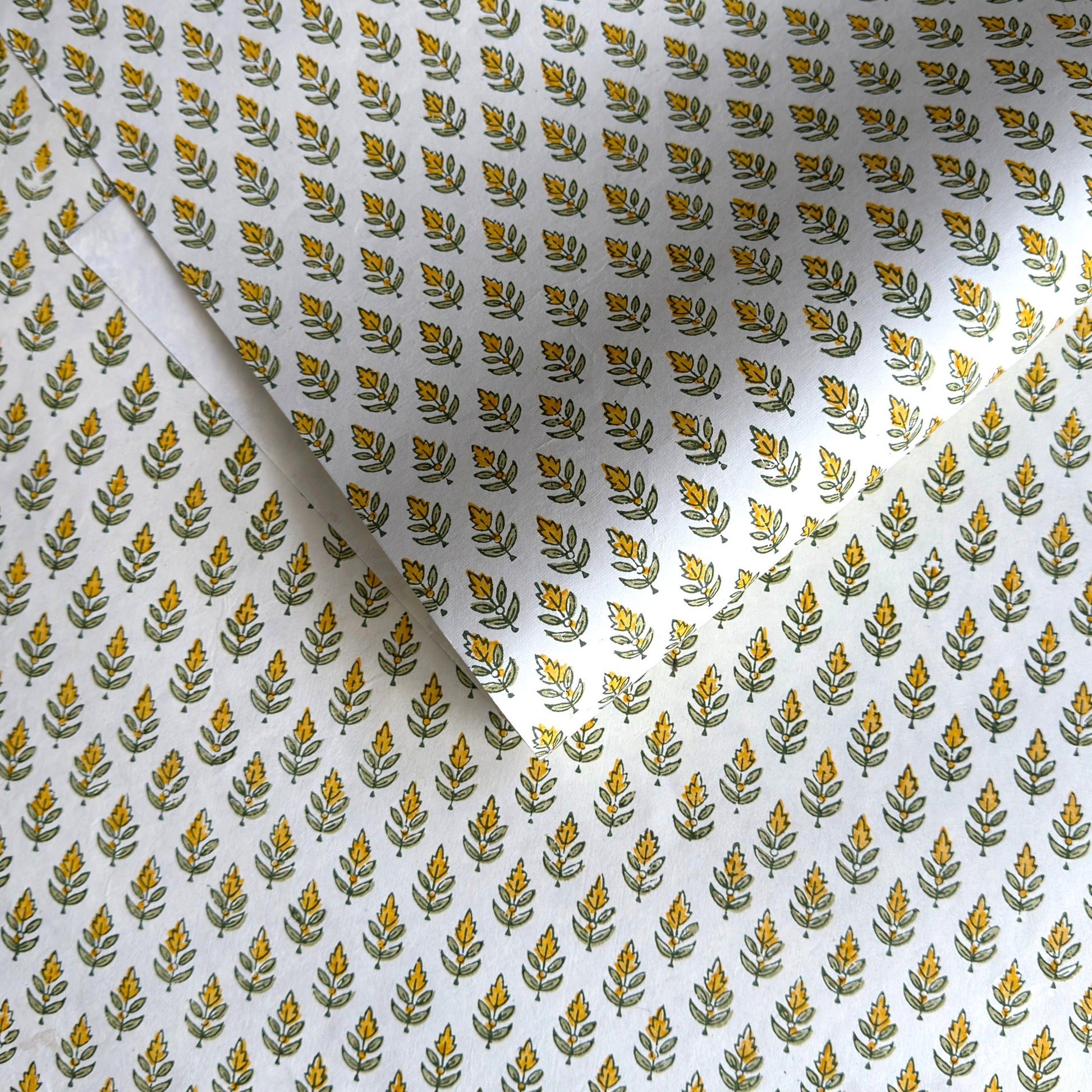 Wrapping paper with block print small flower motif in yellow and green, white background by Paper Mirchi