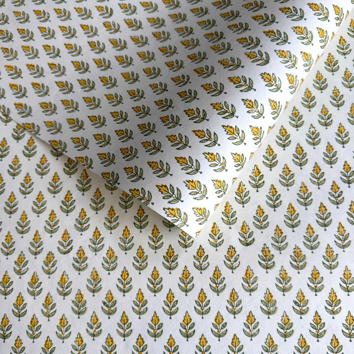Wrapping paper with block print small flower motif in yellow and green, white background by Paper Mirchi