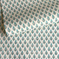 hand block printed wrapping paper by paper mirchi with a repeat floral pattern in turquoise and soft green on white backdrop