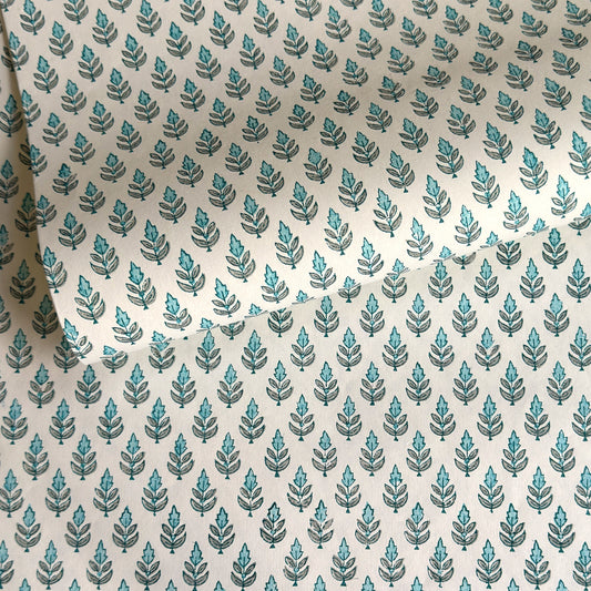 hand block printed wrapping paper by paper mirchi with a repeat floral pattern in turquoise and soft green on white backdrop