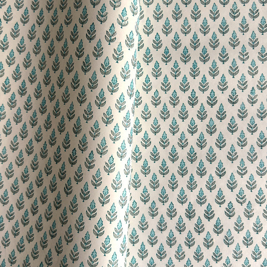hand block printed wrapping paper by paper mirchi with a repeat floral pattern in turquoise and soft green on white backdrop