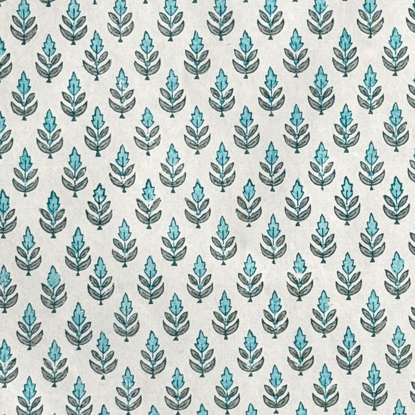 hand block printed wrapping paper by paper mirchi with a repeat floral pattern in turquoise and soft green on white backdrop
