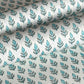 hand block printed wrapping paper by paper mirchi with a repeat floral pattern in turquoise and soft green on white backdrop. close up