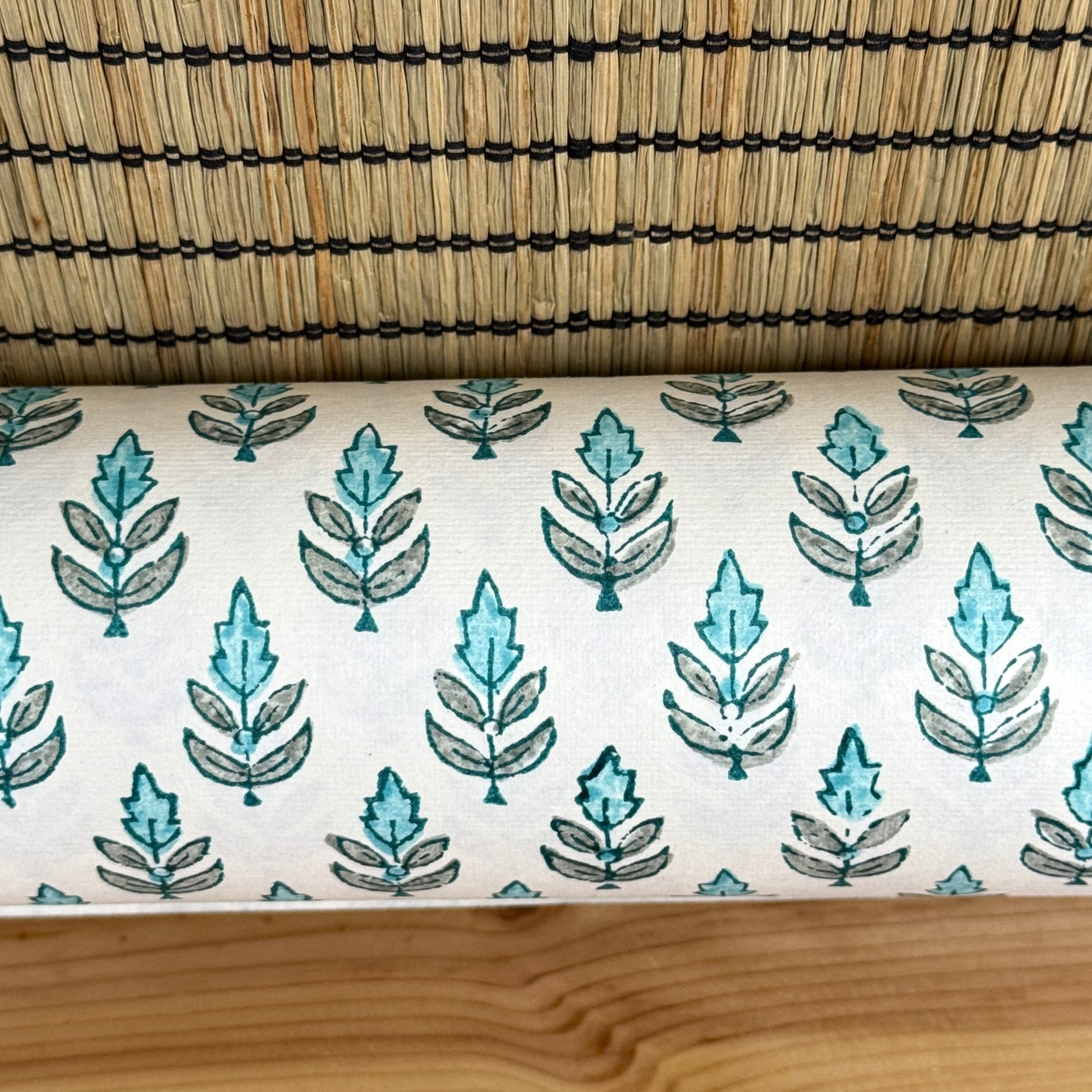 hand block printed wrapping paper by paper mirchi with a repeat floral pattern in turquoise and soft green on white backdrop