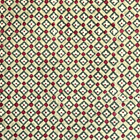 Hand block printed wrapping paper with a floral checked pattern in sage green and red.