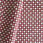 Hand block printed wrapping paper with a floral checked pattern in red, green and gold.