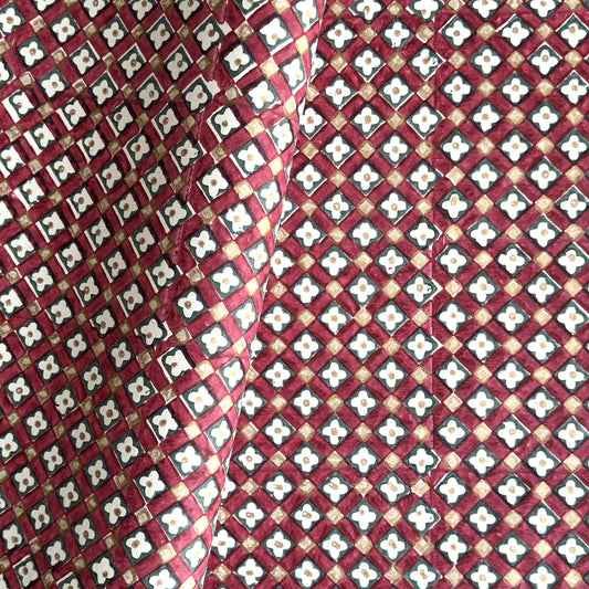 Hand block printed wrapping paper with a floral checked pattern in red, green and gold.