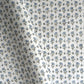 a hand block printed sheet of wrapping paper with a ditsy floral print in soft blue