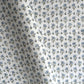 a hand block printed sheet of wrapping paper with a ditsy floral print in soft blue