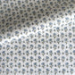 a hand block printed sheet of wrapping paper with a ditsy floral print in soft blue