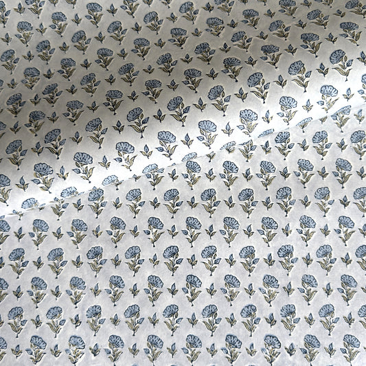 a hand block printed sheet of wrapping paper with a ditsy floral print in soft blue