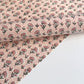 a hand block printed sheet of wrapping paper with a ditsy floral print in pink
