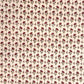 a sheet of hand block printed paper with a ditsy floral design in red and green on pink background