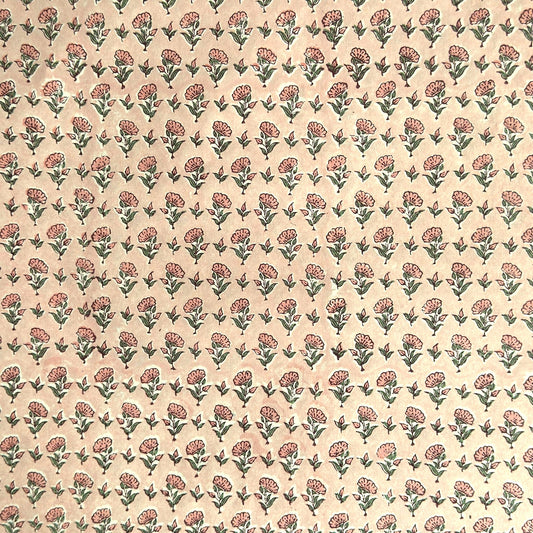 a hand block printed sheet of wrapping paper with a ditsy floral print in pink. Pictured rolled with another design