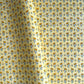 a sheet of hand block printed wrapping paper with a ditsy floral flower design in yellow