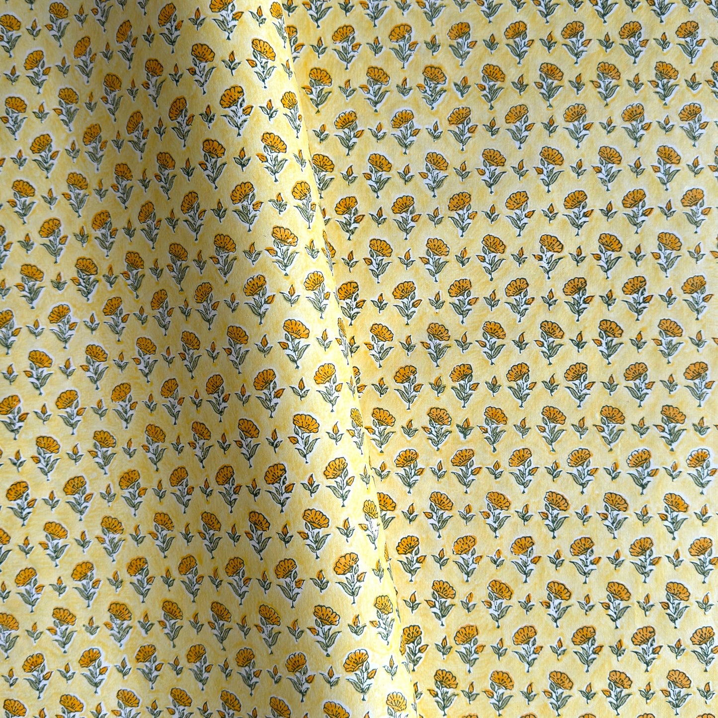 a sheet of hand block printed wrapping paper with a ditsy floral flower design in yellow