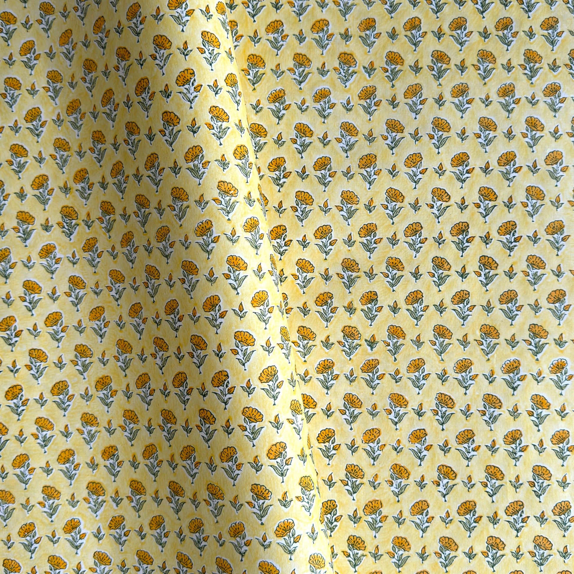 a sheet of hand block printed wrapping paper with a ditsy floral flower design in yellow