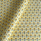 a sheet of hand block printed wrapping paper with a ditsy floral flower design in yellow