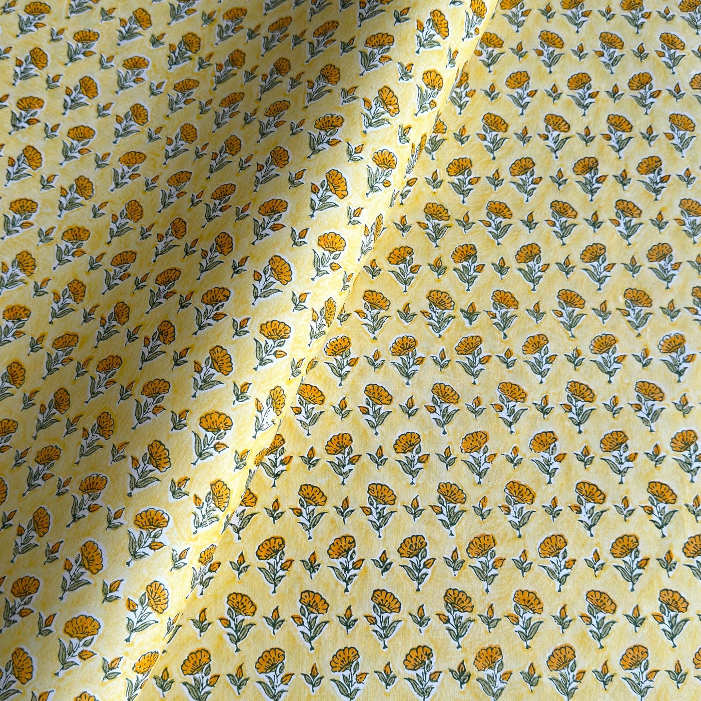 a sheet of hand block printed wrapping paper with a ditsy floral flower design in yellow