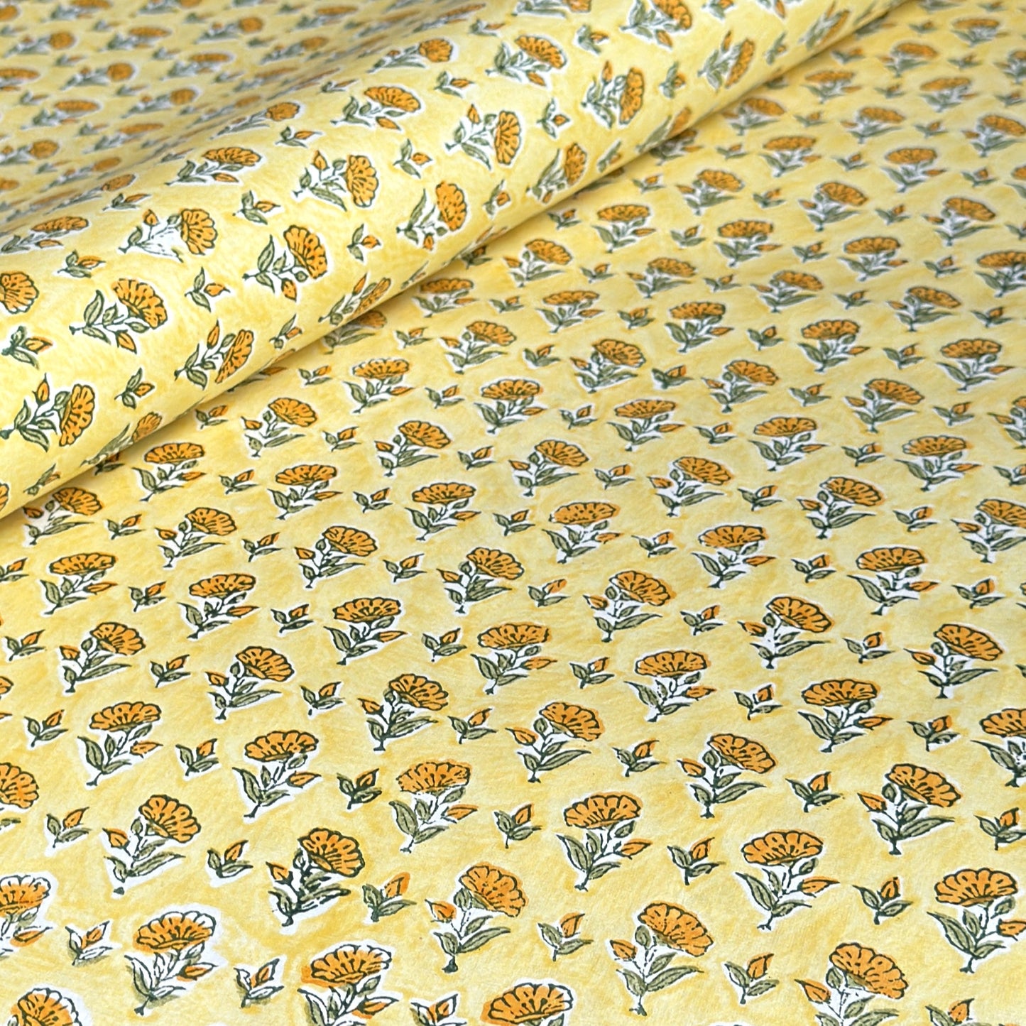 a sheet of hand block printed wrapping paper with a ditsy floral flower design in yellow