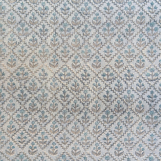 a sheet of hand block printed wrapping paper with a floral lattice design in soft blue