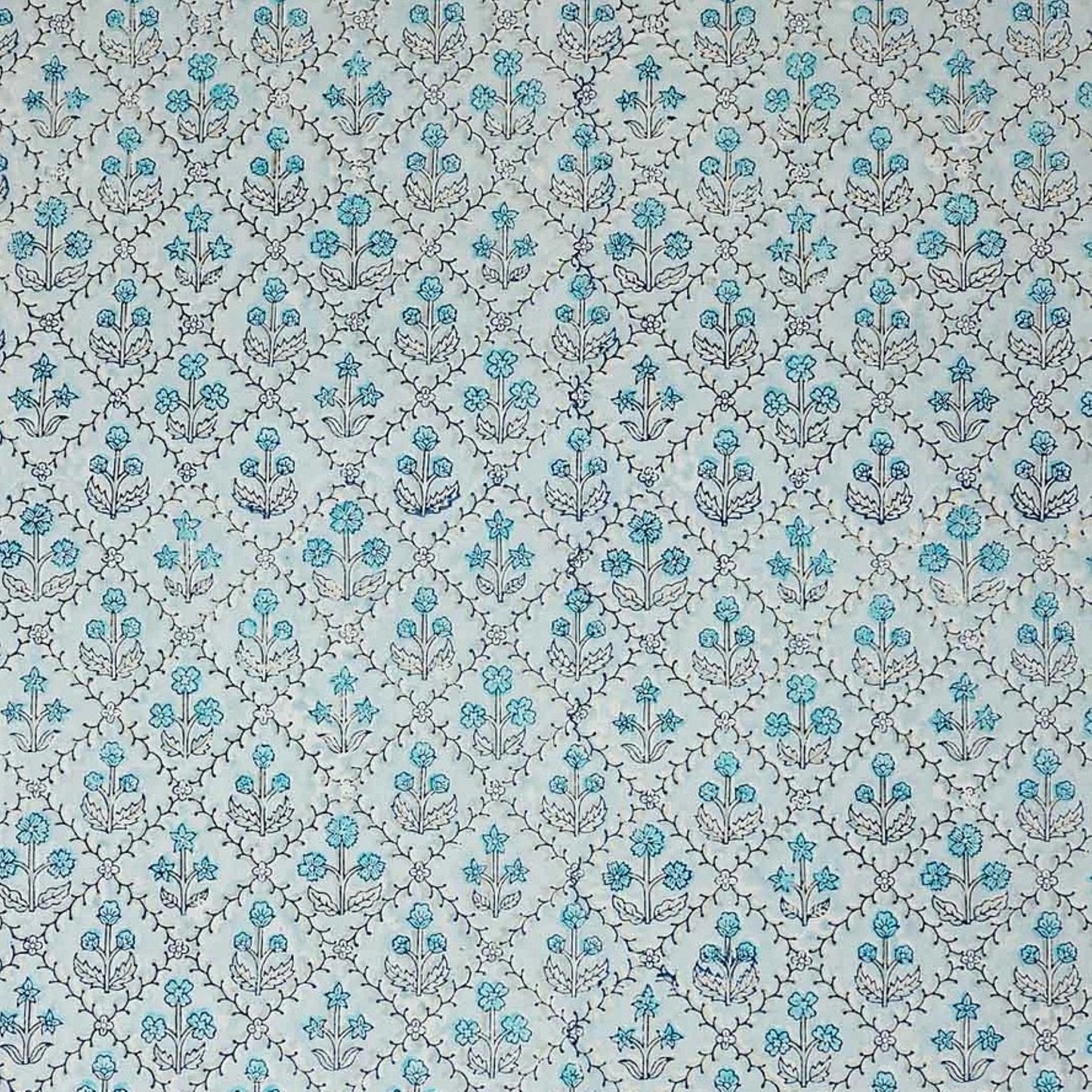 a sheet of hand block printed wrapping paper with a floral lattice design in soft blue