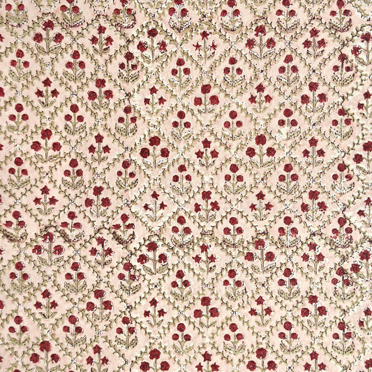 a sheet of hand block printed paper with a floral trellis design in blush pink, sage green and deep red