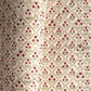 a sheet of hand block printed paper with a floral trellis design in blush pink, sage green and deep red