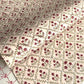 a sheet of hand block printed paper with a floral trellis design in blush pink, sage green and deep red