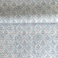 a sheet of hand block printed wrapping paper with a floral lattice design in soft blue