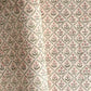 a sheet of hand block printed wrapping paper with a floral trellis design in coral pink and sage green